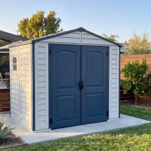 Front view of Duramax Ridgeline 8x6 vinyl storage shed in a residential backyard