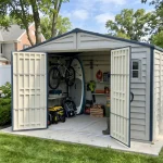 Duramax RidgeLine 10.5' x 8' vinyl storage shed beside a home in a landscaped backyard