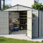 Duramax RidgeLine 10.5 x 13 vinyl storage shed beside a modern home with the double doors open and organized gear inside
